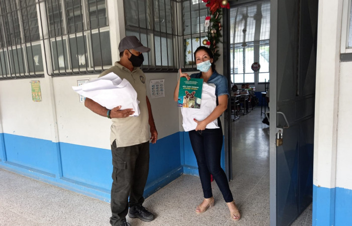 Docente recibiendo su ejemplar luego de participar en el taller con docentes del 2021.