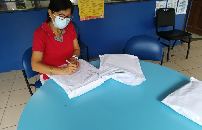 Docente firmando el oficio de recibido del ejemplar que le corresponde, de la guía ACG, 4 ventanas al Cambio Climático.